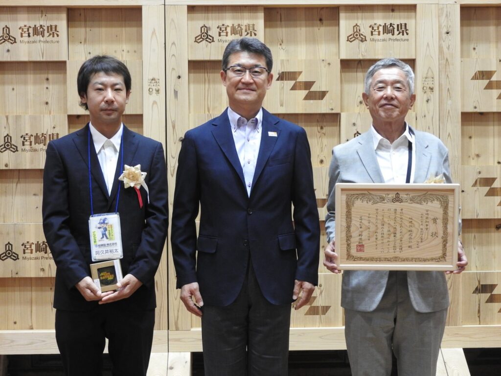宮崎県知事から賞状を受け取った旭建設の受賞者2名と河野俊嗣宮崎県知事