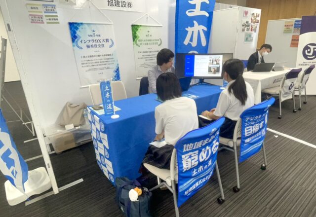 旭建設ブースで学生に会社説明を行う社員