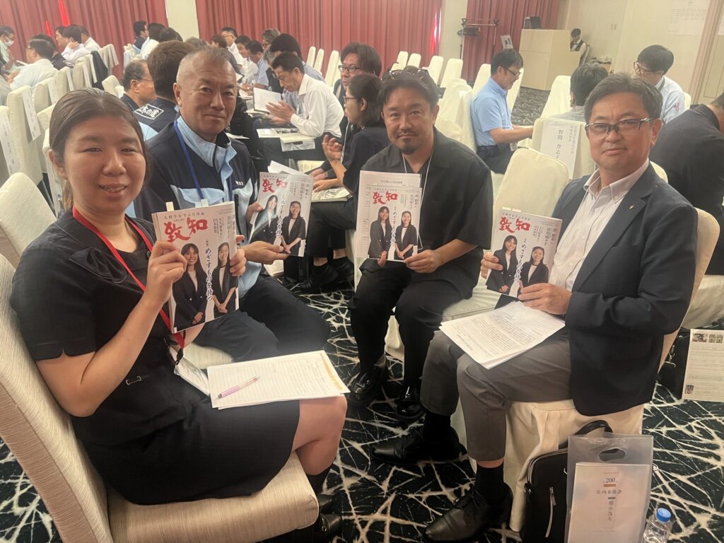 『致知』を手に笑顔を見せる社内木鶏会の参加者