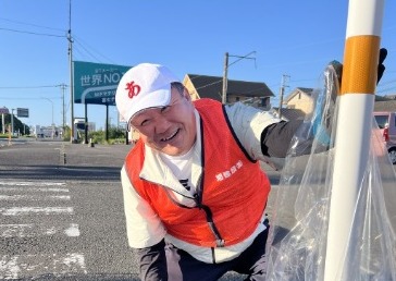 歩道でごみを拾い集める社員