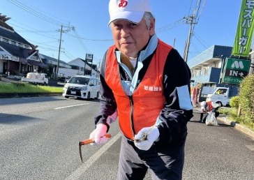 火バサミでごみを拾う社員