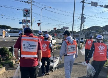 国道沿いの歩道を区間ごとに分かれて清掃する様子