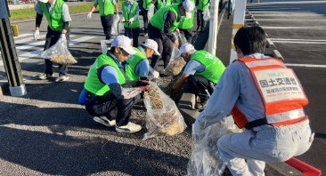 側溝にたまった土砂と落ち葉をかき出す様子