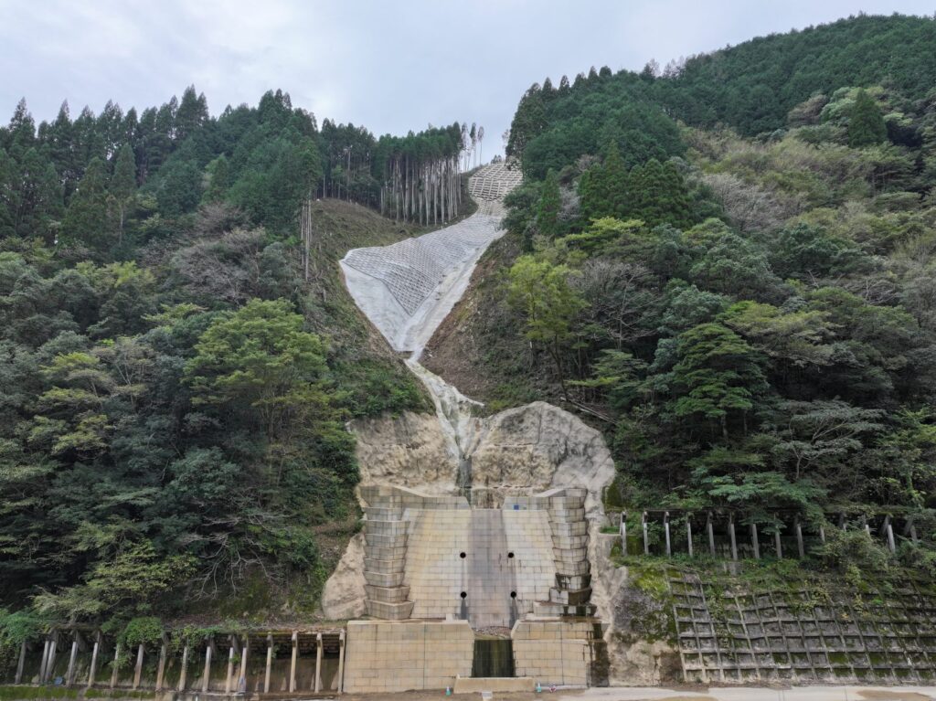 完成した砂防堰堤と、その上流の渓流に施工した法面工