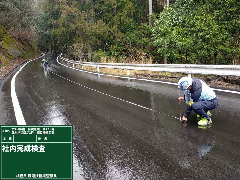舗装補修を終えた山あいの道路で、社内完成検査を行う様子