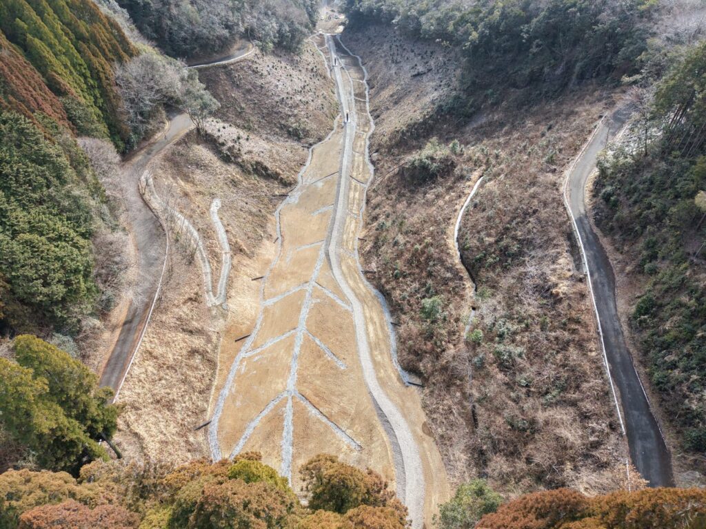 上空から見た薑谷地区。切り開いた道路の敷地と、盛土の下に敷いた地下排水工