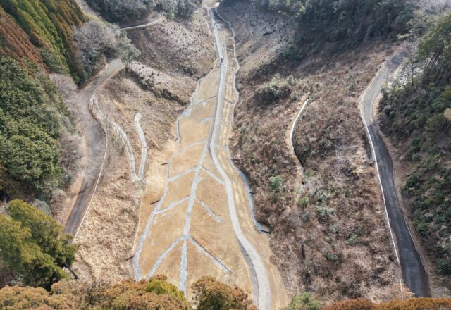 上空から見た薑谷地区。切り開いた道路の敷地と、盛土の下に敷いた地下排水工