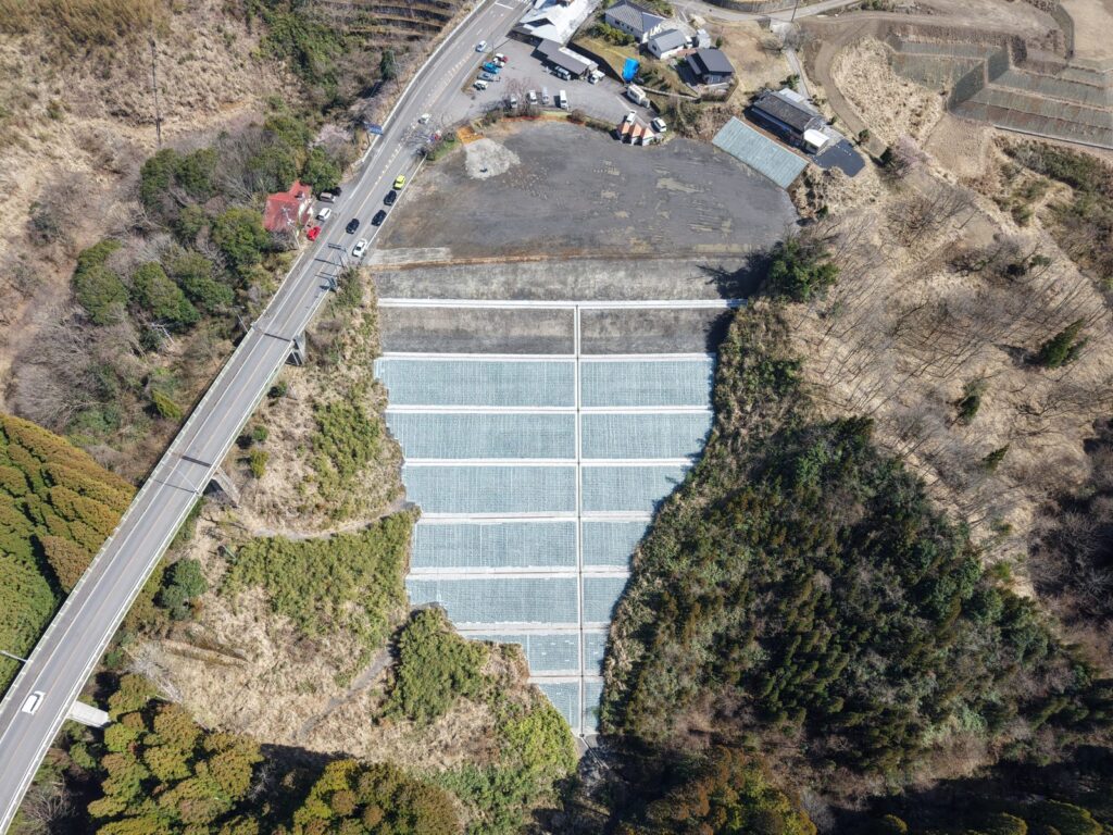 真上から見た花の群地区。工事用道路のために造った平場と、その下の法面。左は国道218号