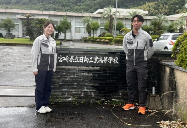 宮崎県立日向工業高等学校の銘板の前で、参加した当社の社員